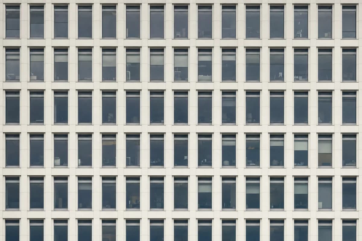 The facade of an office building shot square-on as a strict grid of identical window bays