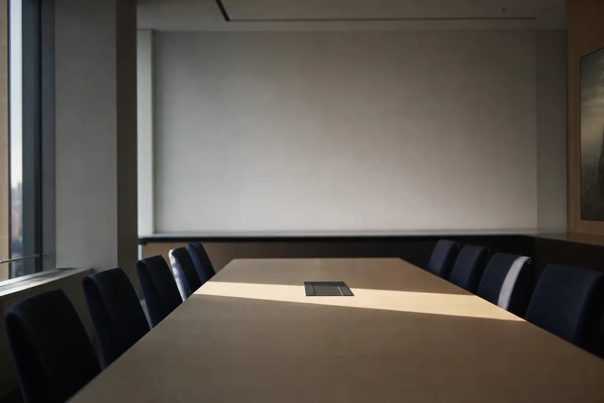 An empty boardroom in early morning with sunlight falling across the table