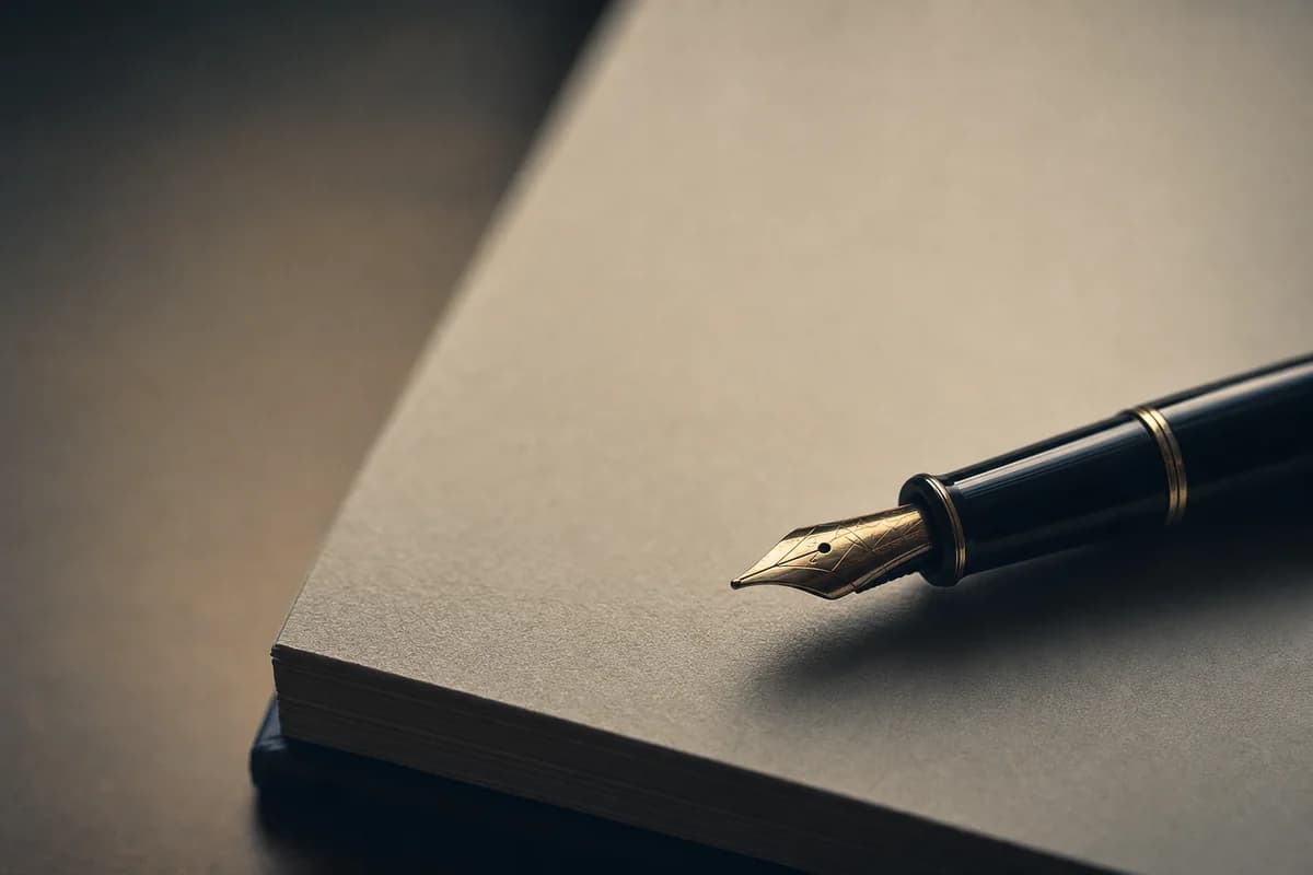 A fountain pen resting on the signature page of a bound printed report