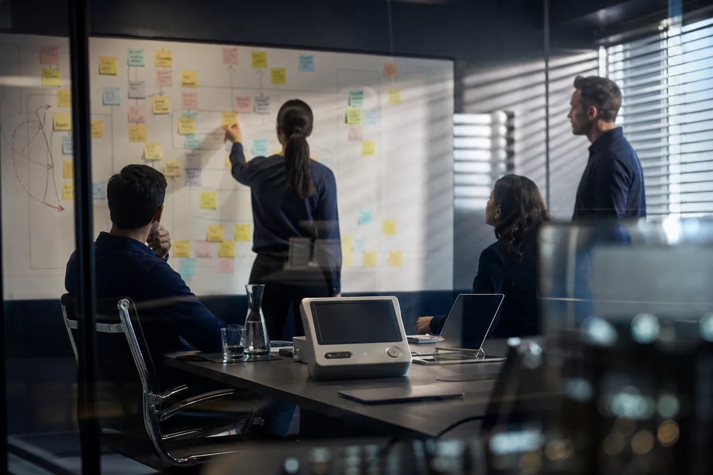 Engineers mapping device risks with sticky notes on a whiteboard