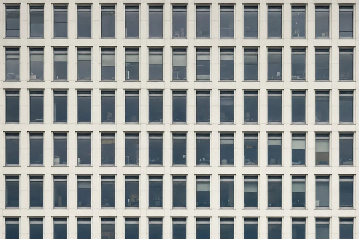 The facade of an office building shot square-on as a strict grid of identical window bays